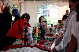 Guests shop at tables filled with festive souvenirs. Custom-designed baby clothes, magnets, napkins and other toys were all sold at the festival.